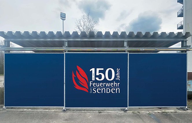 Bild eines Bauzauns mit dem Schriftzug und Keyvisual "150 Jahre Feuerwehr"
